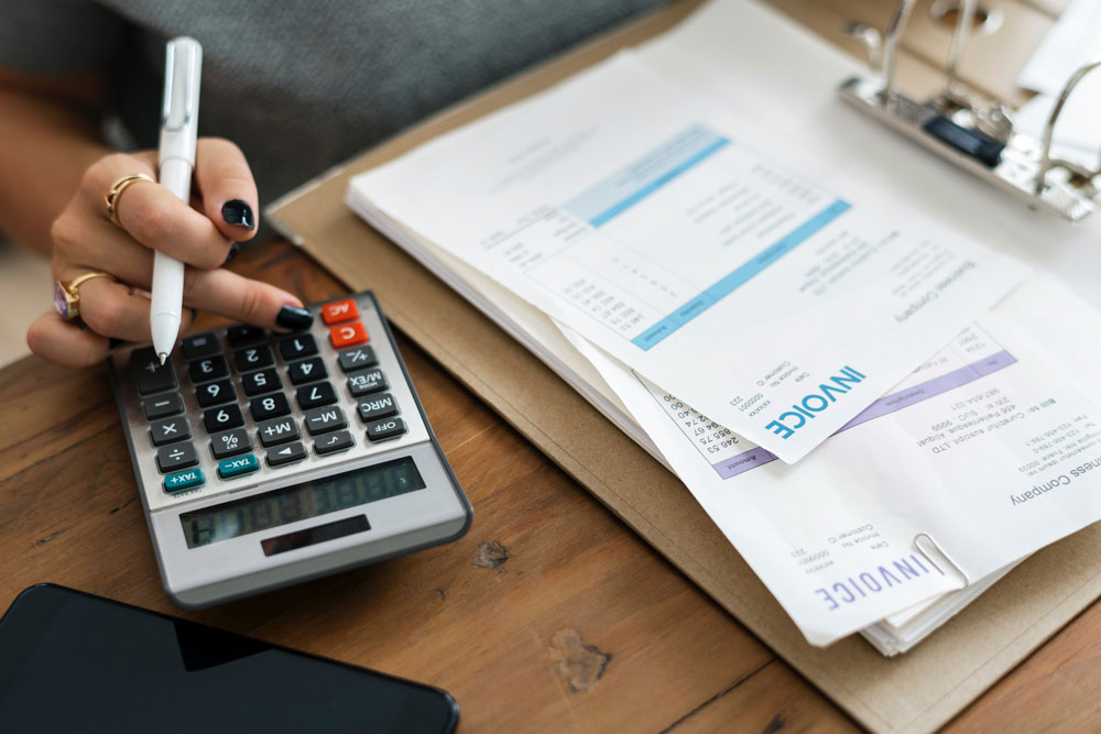 Accountant using calculator and looking at reports