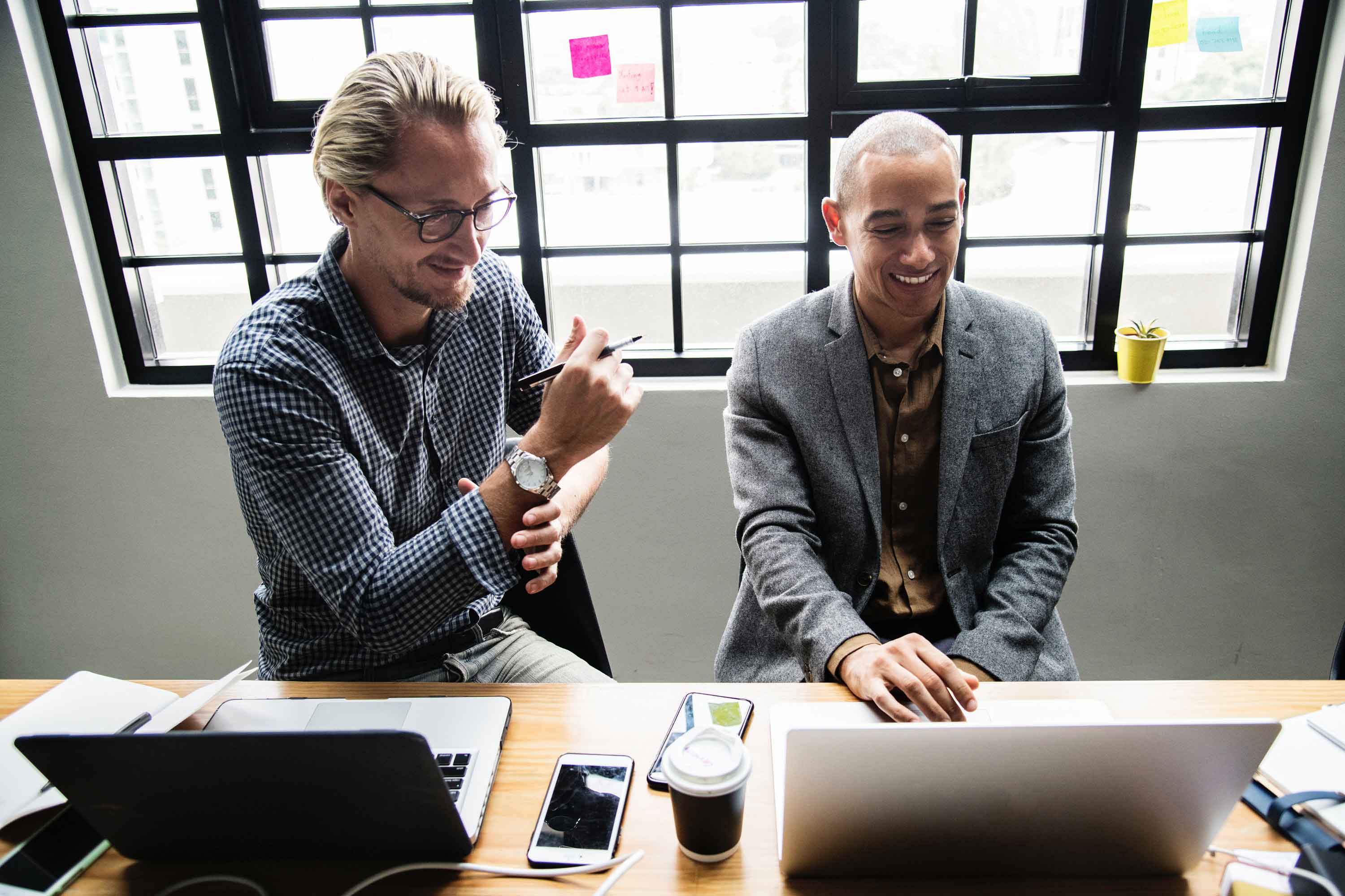 two professionals working on their laptops 